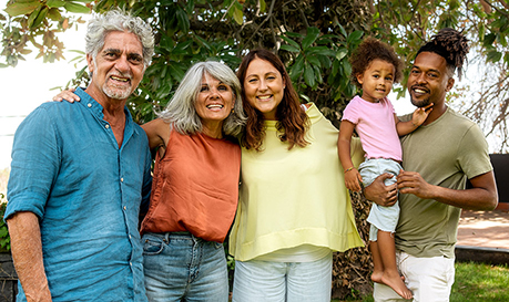 Multigenerational family posing for a photo outside.