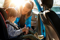 image-8 Toddler being buckled in car seat by mom